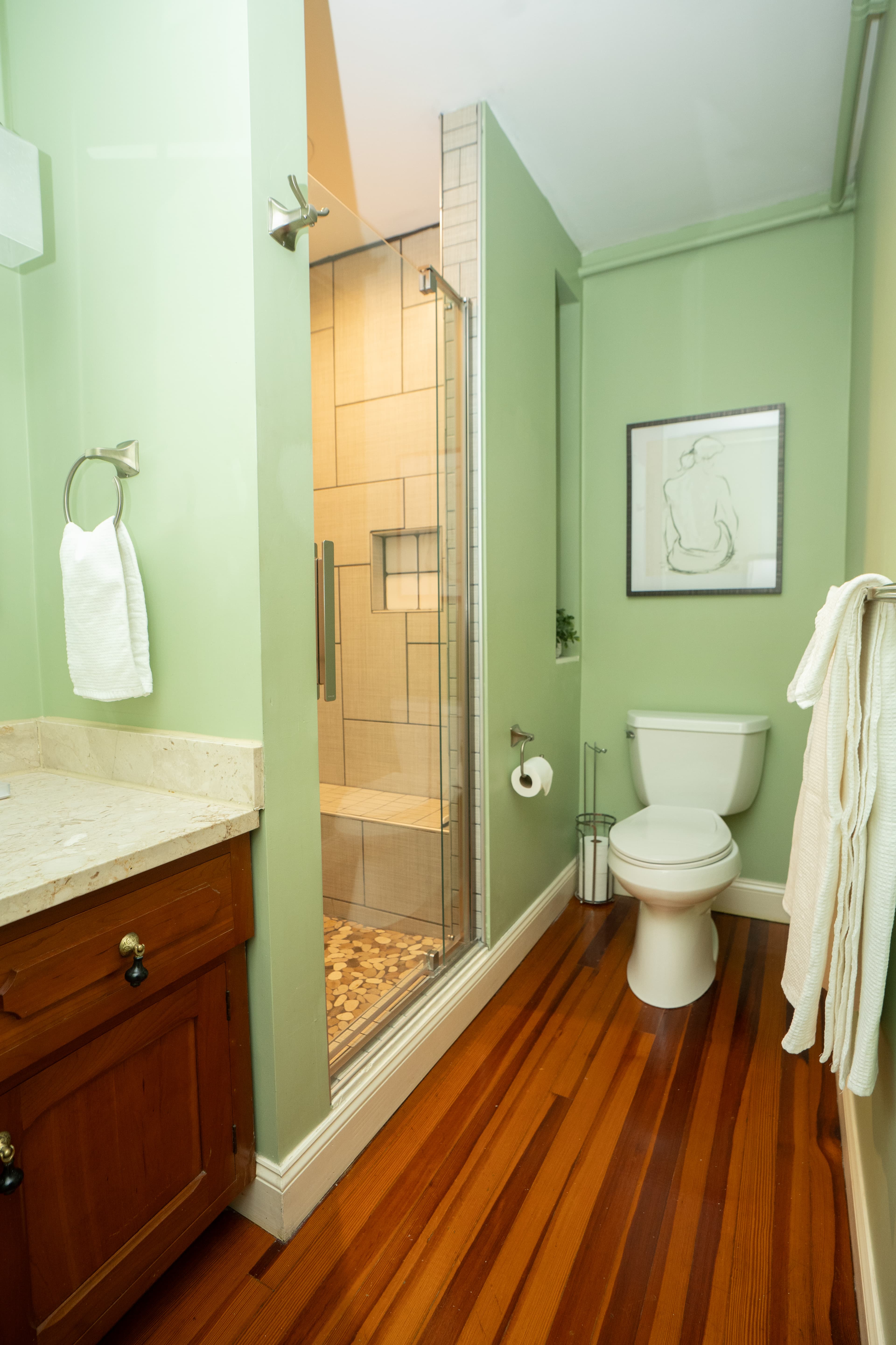 Baumgardner Room en-suite bath with walk-in shower, shelves, and vanity