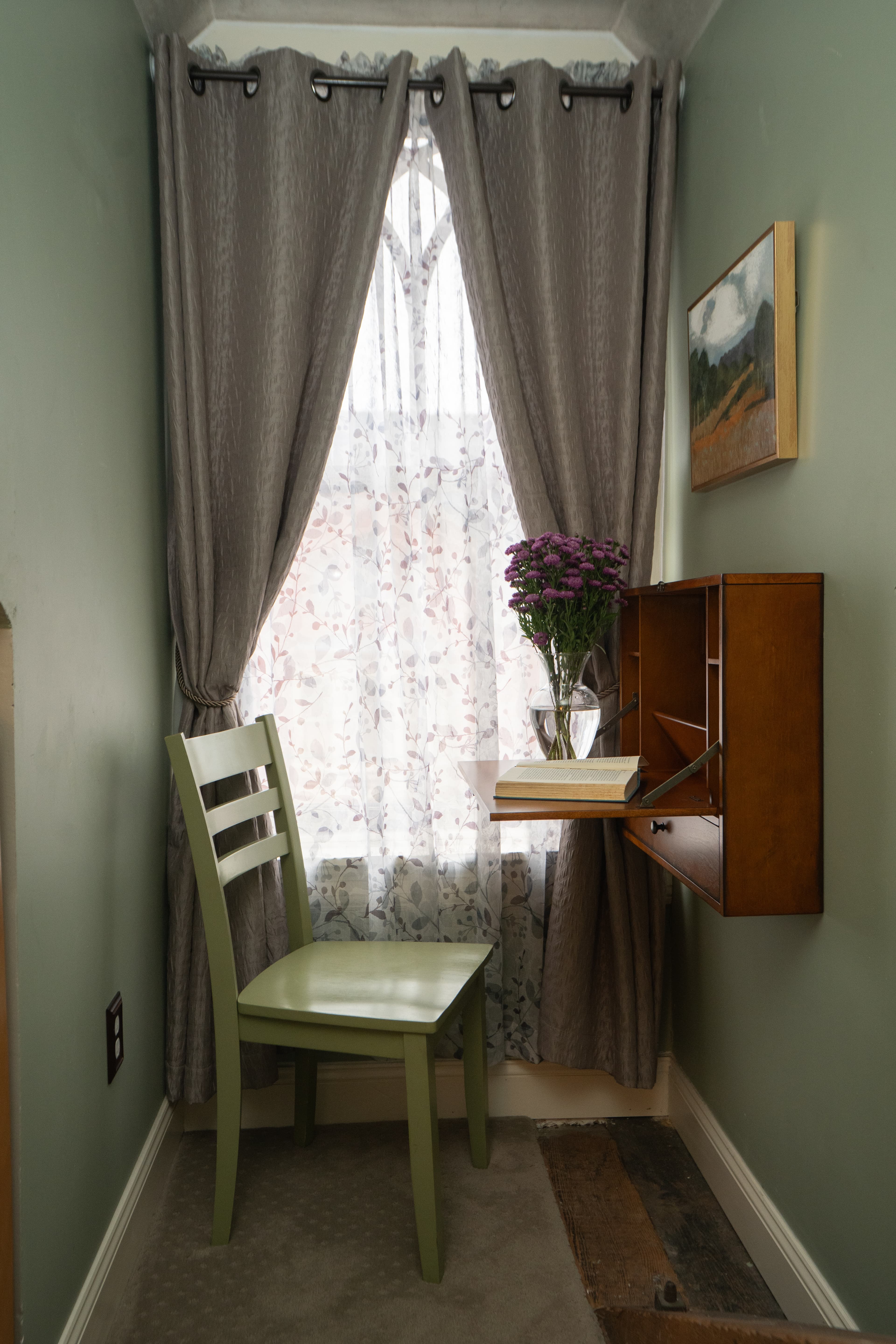 Desk area in the Parsons Room with wall-mounted desk, painting and green chair