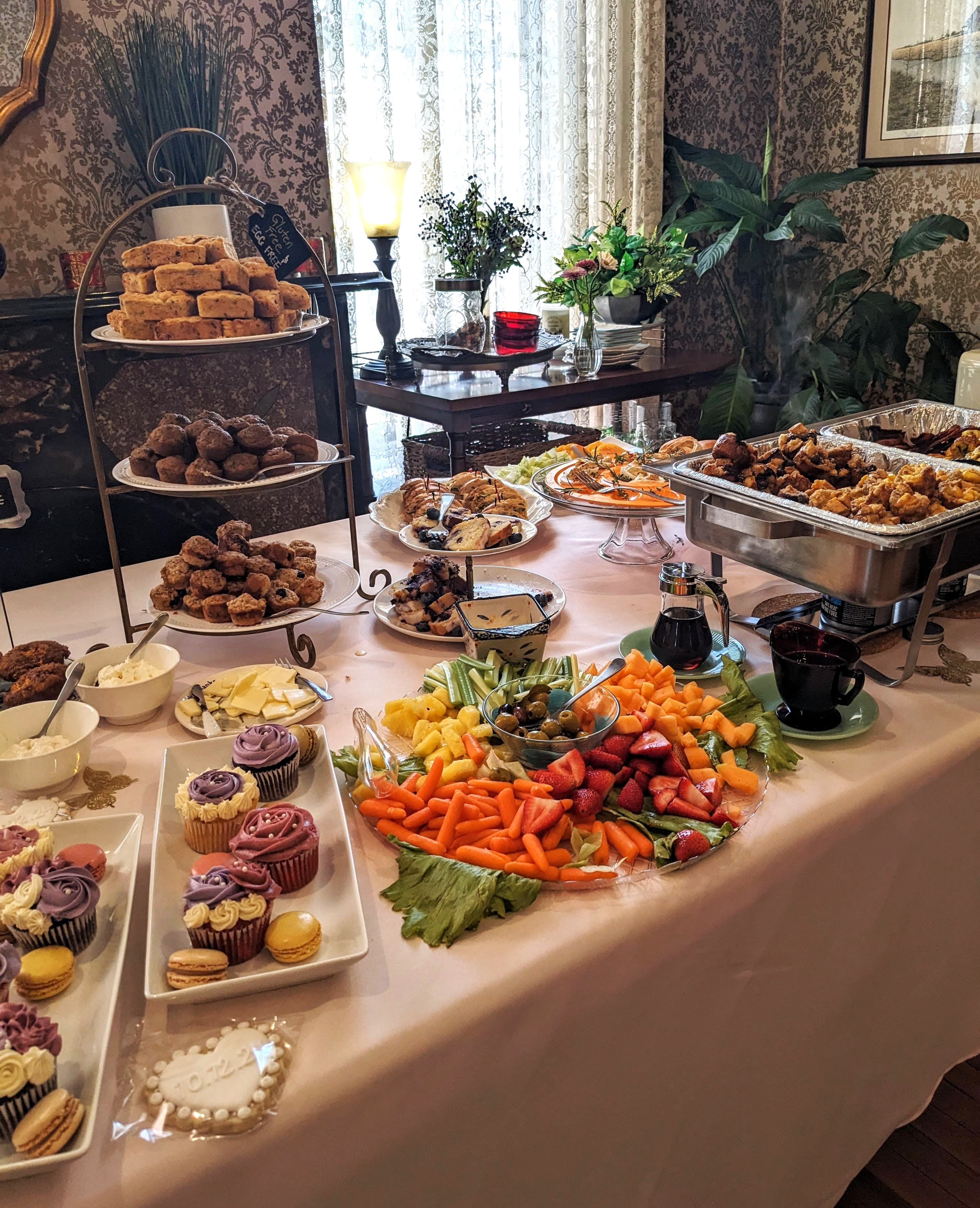 A beautifully arranged buffet featuring various pastries, fruits, vegetables, and beverages.