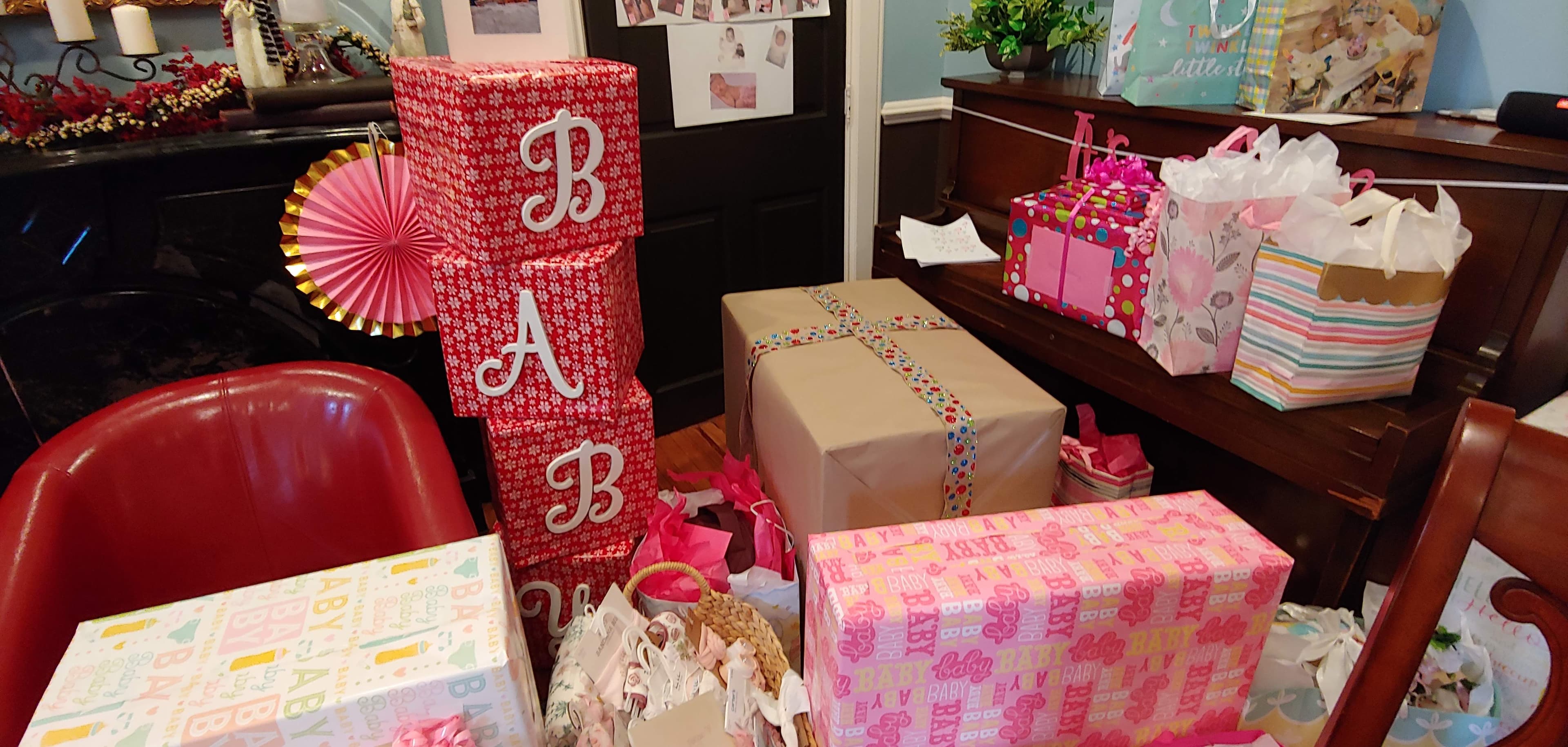 A collection of brightly wrapped gifts in various sizes and colors, with the letters "B A B" displayed prominently.