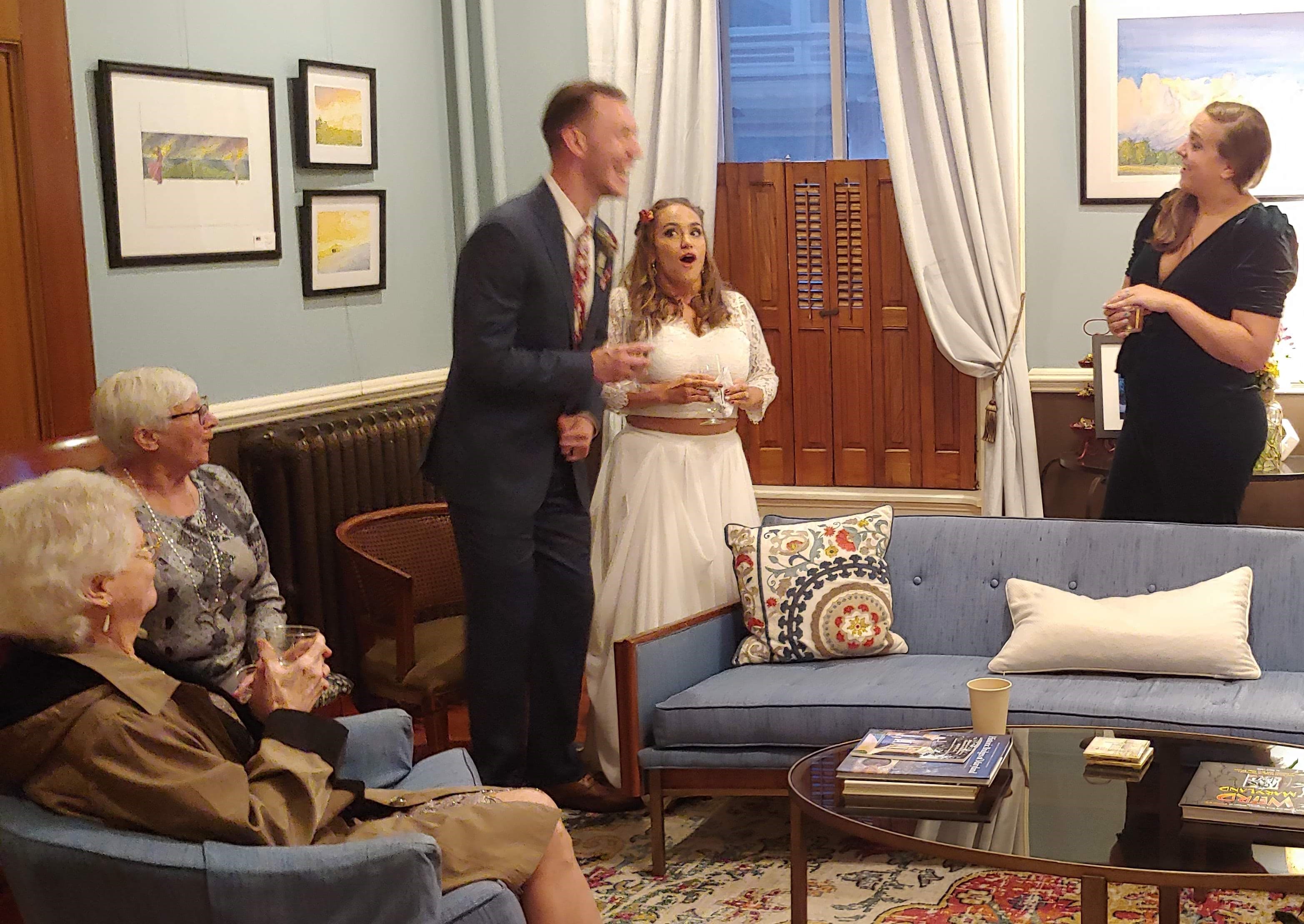 A group of four people are engaged in lively conversation in a cozy indoor setting.