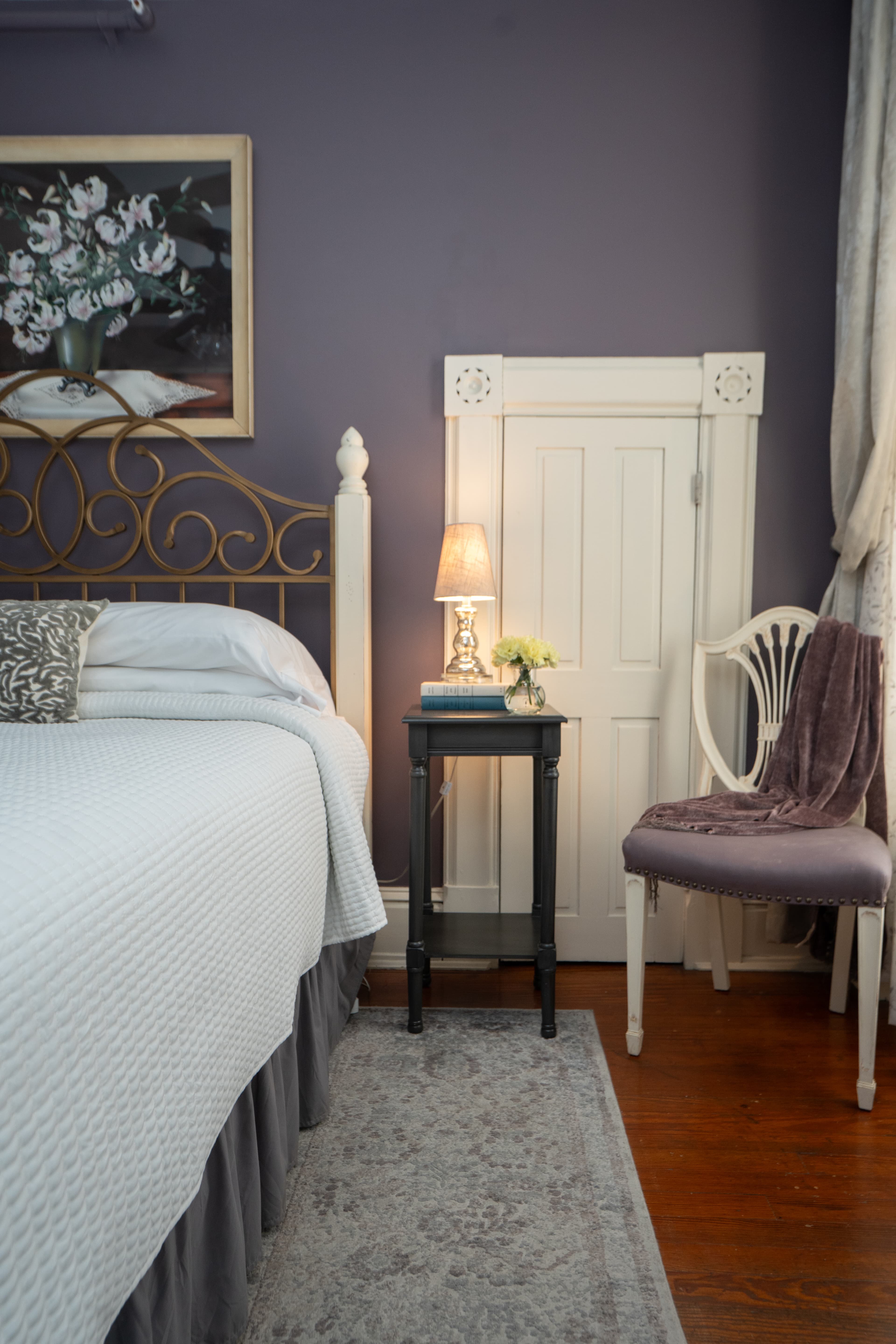 Detail view of the nightstand and side chair in the Wilt Room with a purple throw