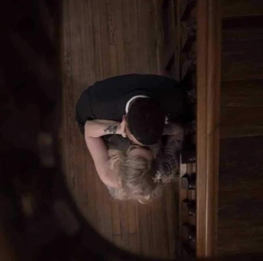 A couple shares a kiss while embracing on a staircase, viewed from above.